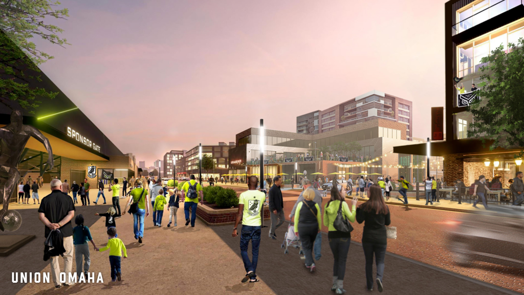 A street view from outside Union Omaha's proposed new stadium, showing fans walking along the street before a match.