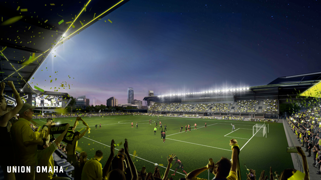 A view inside Union Omaha's proposed new stadium, showing sections of fans cheering with the downtown Omaha skyline in the background.