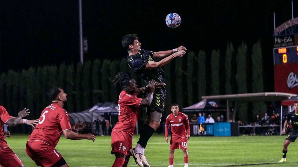 Union Omaha player going up for a header against Central Valley Fuego
