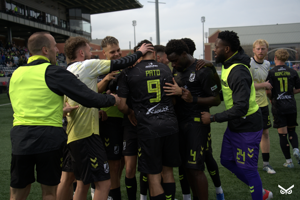 Union Omaha players celebrate with Pato Botello Faz after his game-winning goal against Madison.