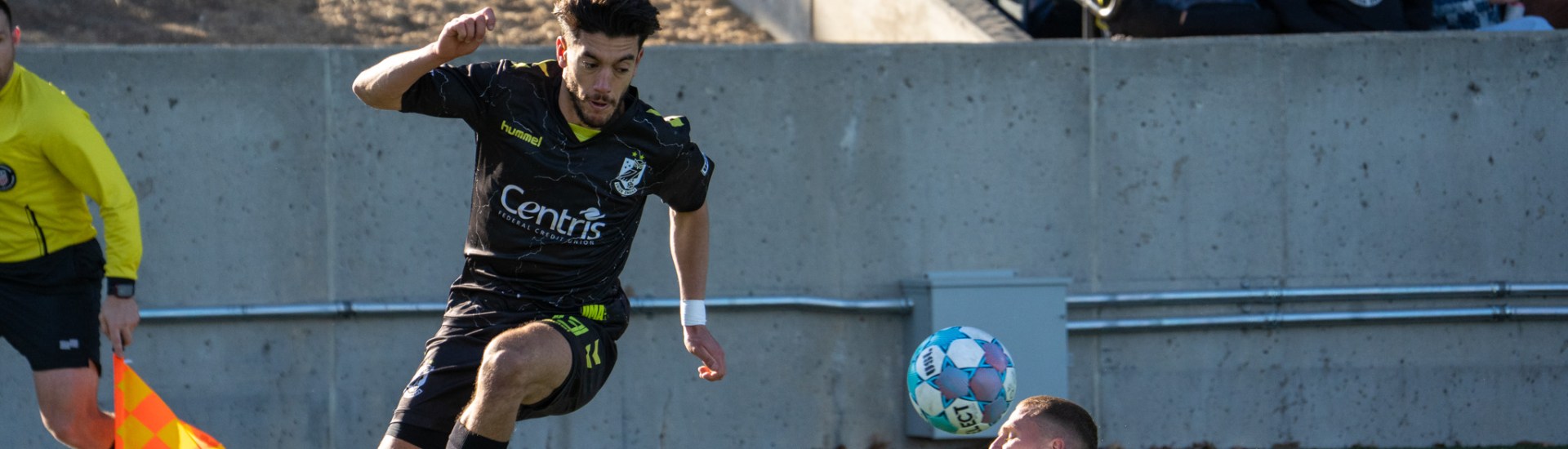 Younes Boudadi dribbling past a sliding Greenville Triumph player